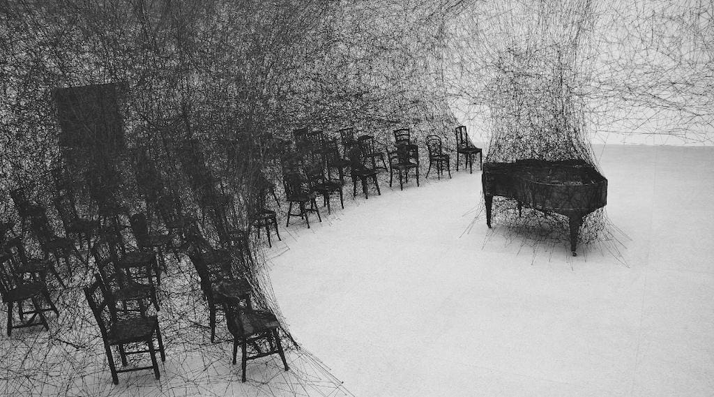 Shiota Chiharu In Silence 2008 Burnt piano, burnt chair, black wool Installation view: State of Being, Art Centre Pasquart, Biel/Bienne, Switzerland, 2008 Photo: Sunhi Mang